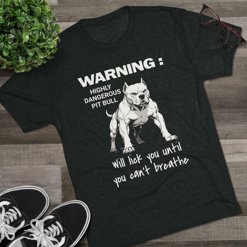 Pit Bull Warning T-Shirt with bold pit bull illustration and humorous "Highly Dangerous Pit Bull Will Lick You Until You Can't Breathe" text on charcoal tri-blend fabric